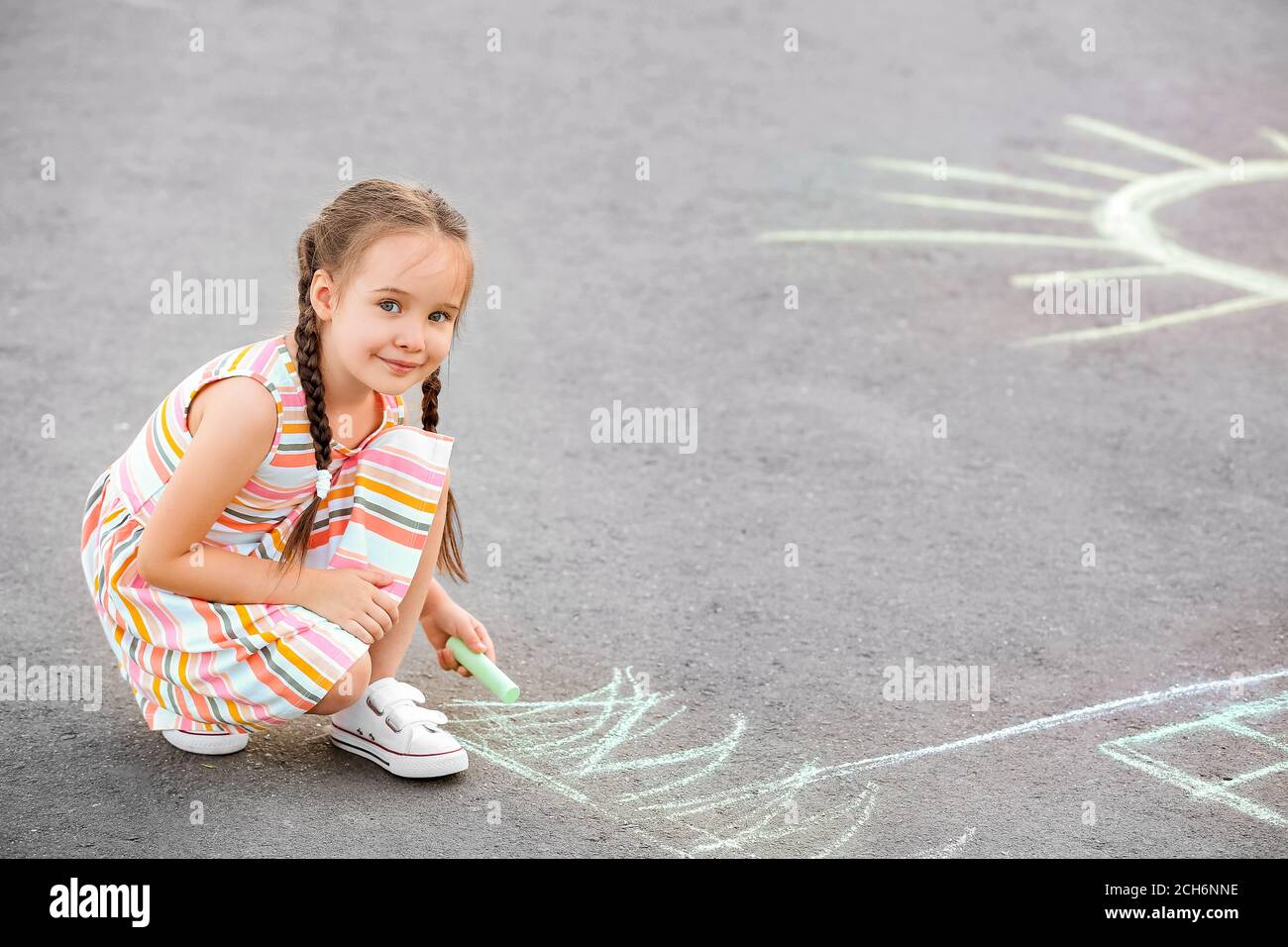 Little girl drawing with chalk on asphalt Stock Photo - Alamy