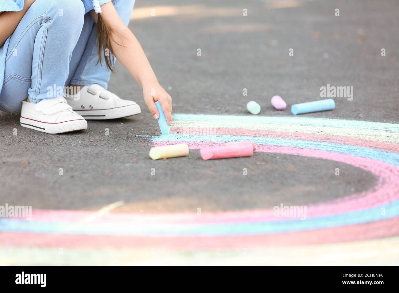 Little girl drawing with chalk on asphalt Stock Photo - Alamy