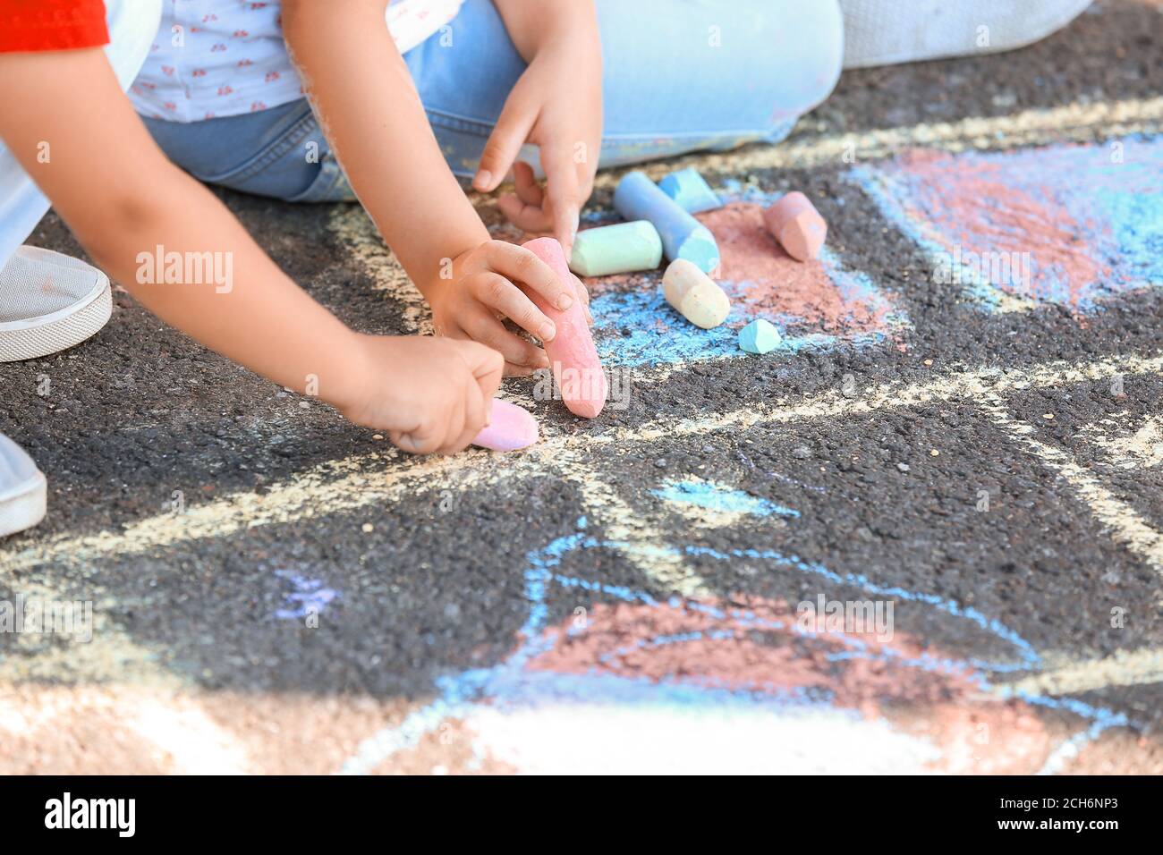Little children drawing with chalk on asphalt Stock Photo - Alamy
