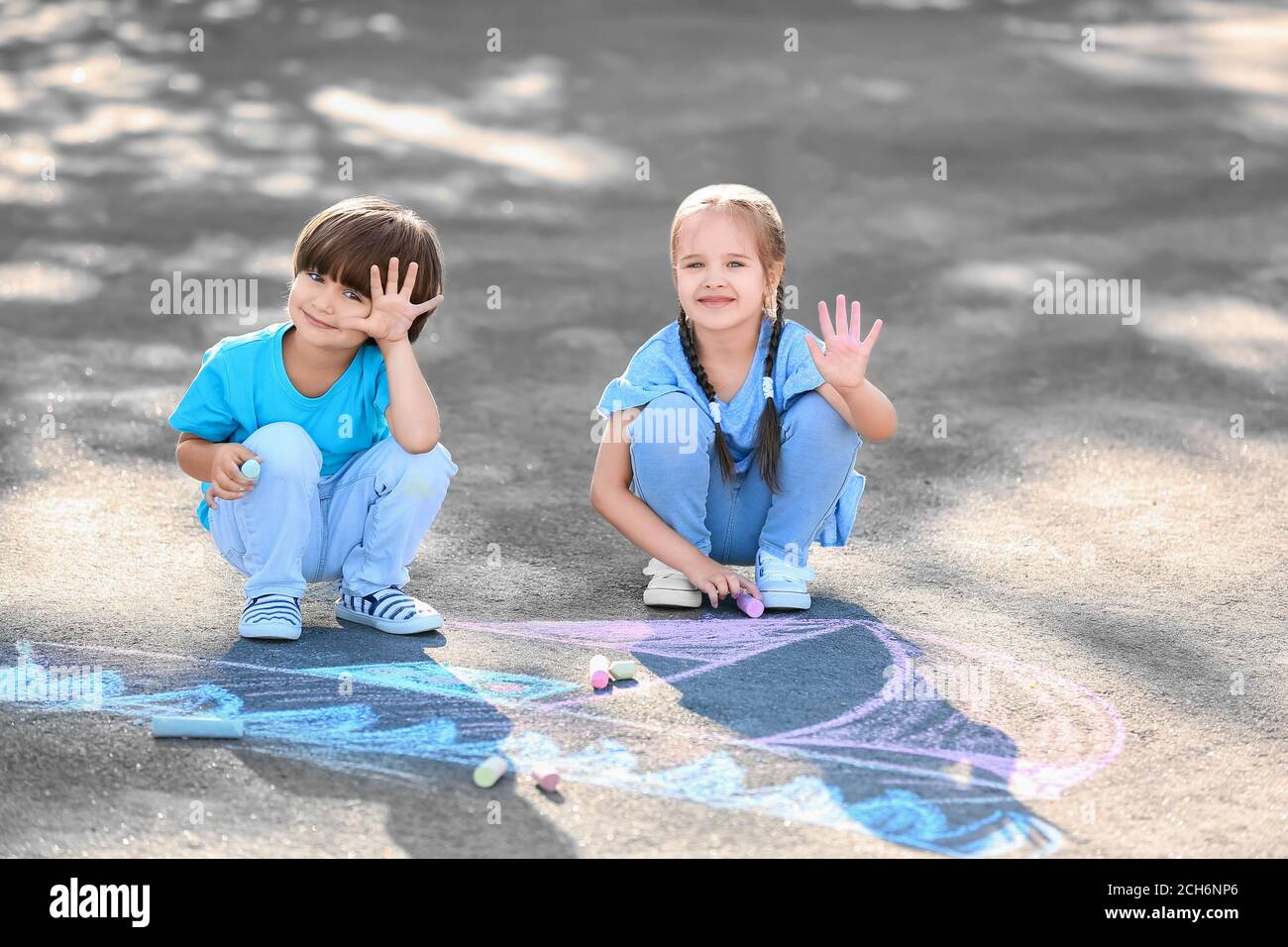 Little children drawing with chalk on asphalt Stock Photo - Alamy