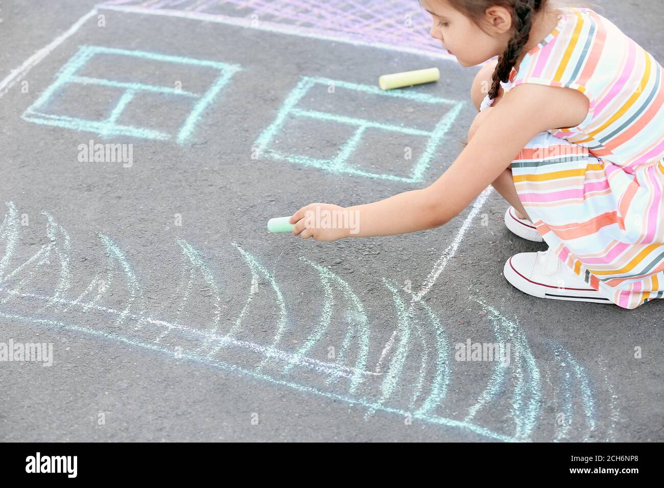 Little girl drawing with chalk on asphalt Stock Photo - Alamy