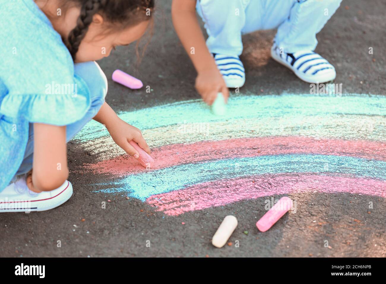 Little children drawing with chalk on asphalt Stock Photo - Alamy