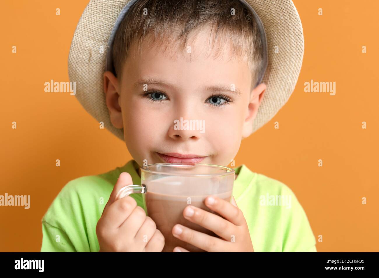 Little boy with tasty chocolate milk on color background Stock Photo