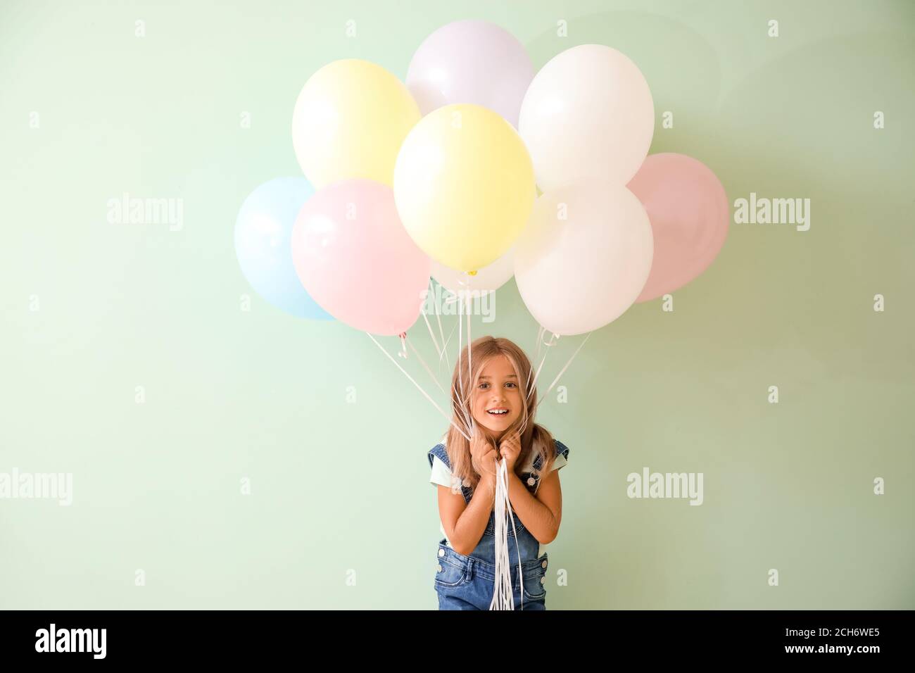 Little girl with balloons on color background Stock Photo - Alamy