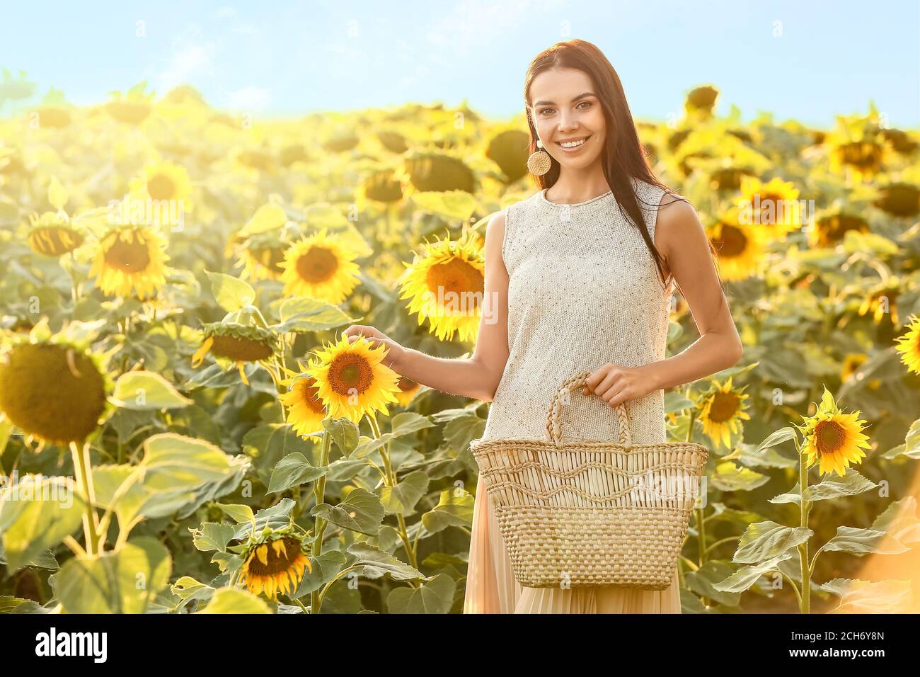 Beautiful young woman in sunflower field Stock Photo - Alamy