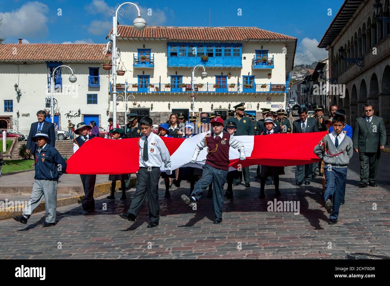 School boys march holding the flag of Peru during a parade to commemorate the upcoming May Day celebrations in Cusco. Stock Photo