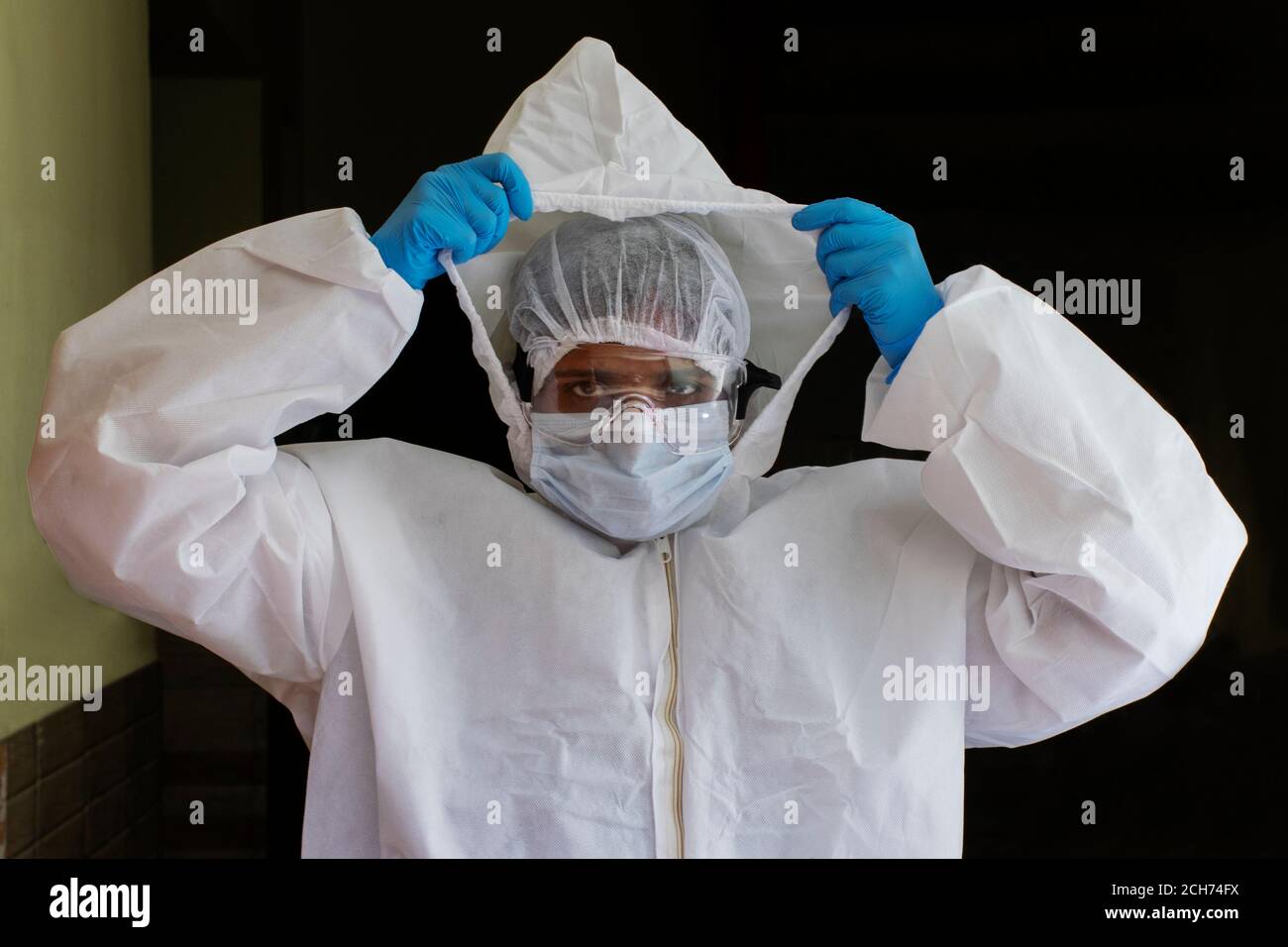 Doctor wearing ppe suit, face surgical mask and visor fighting against corona virus outbreak Stock Photo