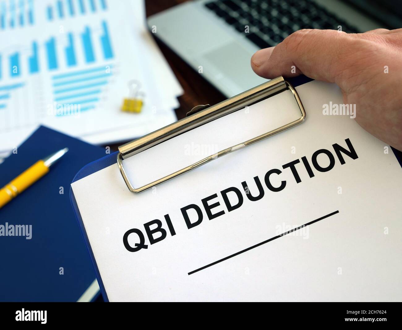 QBI Qualified Business Income Deduction documents in the hand. Stock Photo