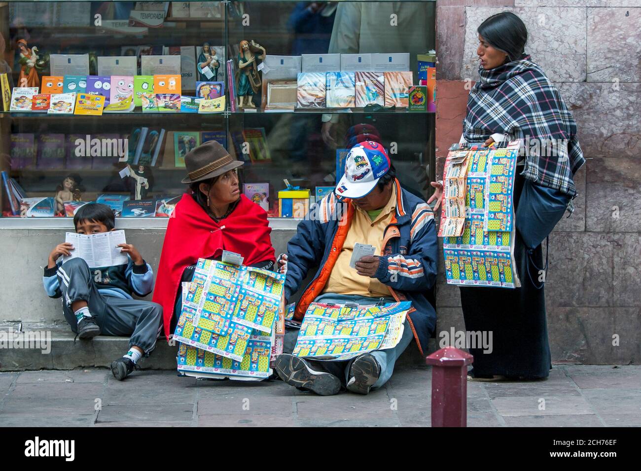 Vendors selling lottery tickets have a rest on the footpath near Independence Square in Quito, the capital of Ecuador. Stock Photo