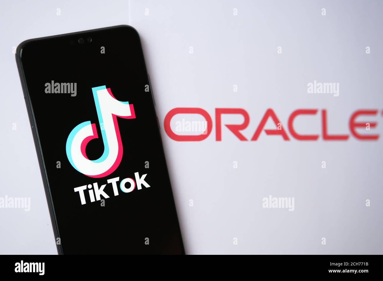 TikTok and Oracle partnership concept photo. TikTok logo seen on the smartphone and Oracle company logo seen on the blurred background. Stock Photo