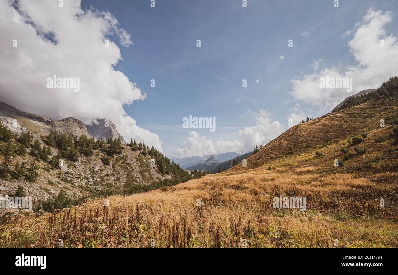 Panorama of a Alpine mountain valley and peaks. High mountain peaks and a glacier and water falls on the Italian side of the Mont Blanc Massive. Stock Photo