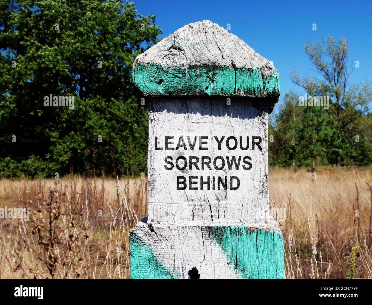 Milestone with sign Leave your sorrows behind. Stock Photo