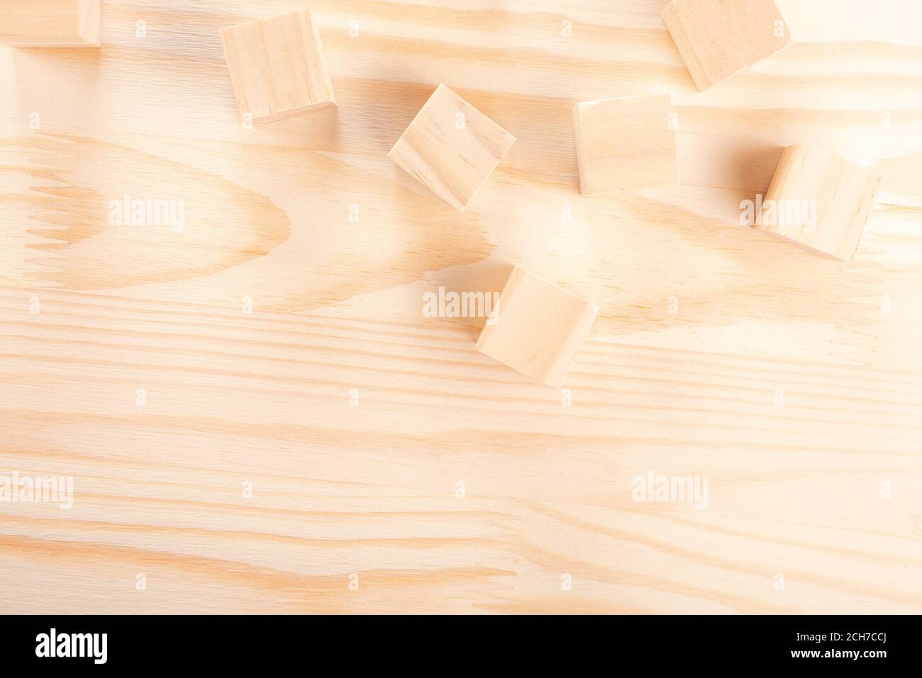 wooden cubes on a light wooden background. warm wooden background. the concept of creativity, products from natural wood, wood crafts. Stock Photo