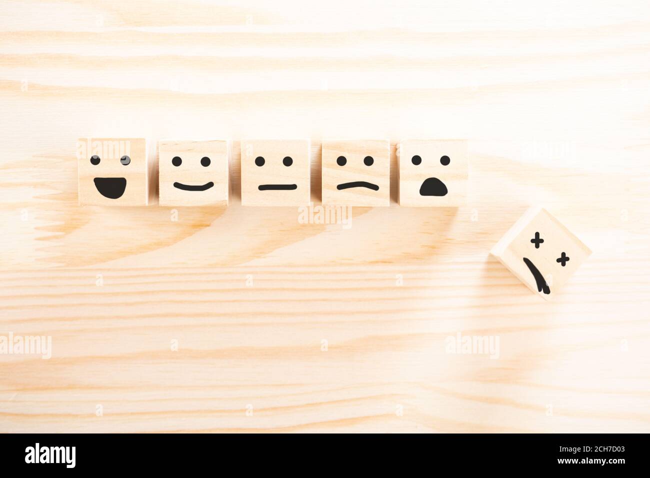 wooden cubes that Express different emotions. smile face icon symbol on wooden cube on wooden background. concept of different emotional state of a pe Stock Photo