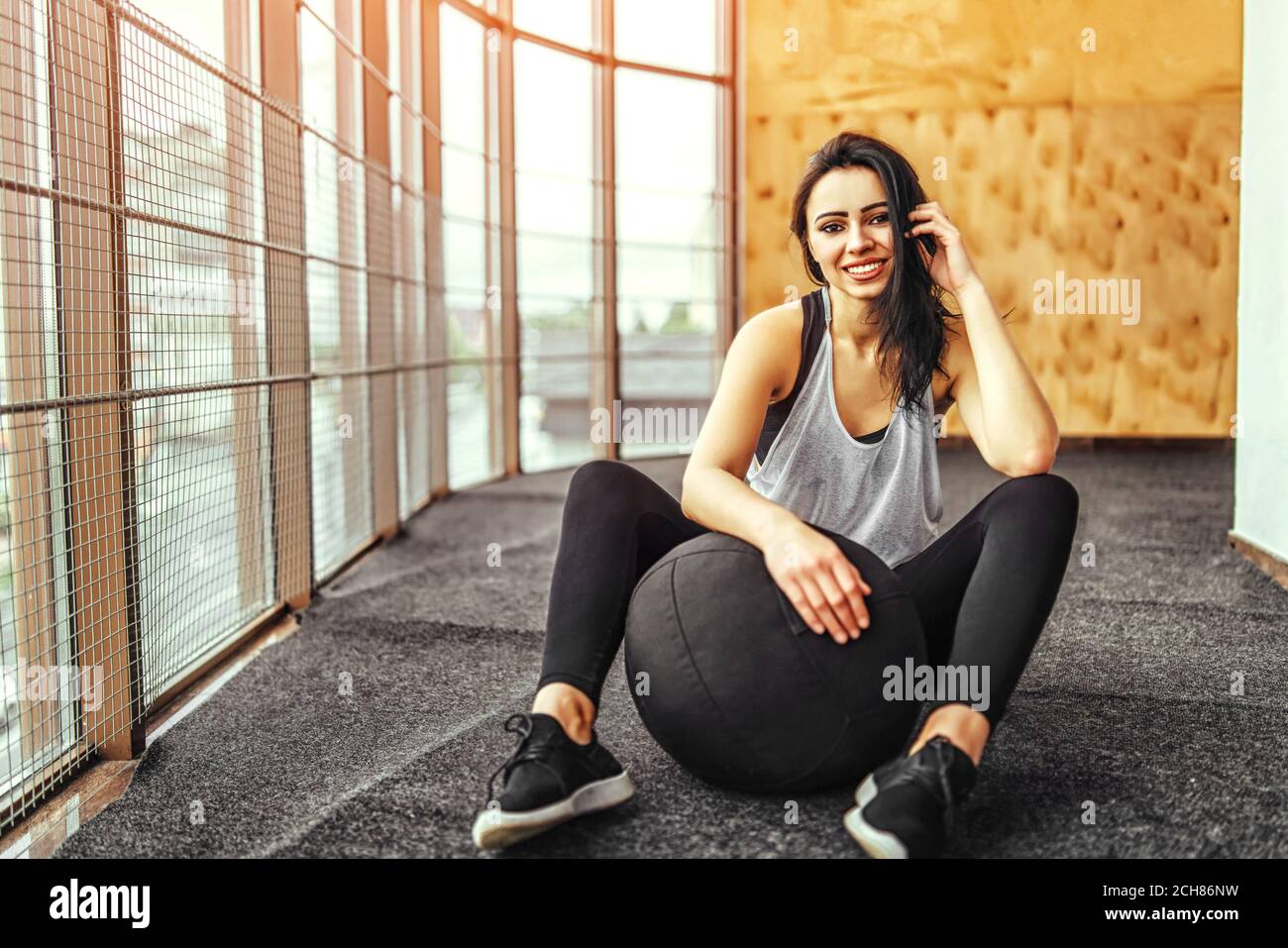 Pretty sporty girl sitting in the gym Stock Photo - Alamy