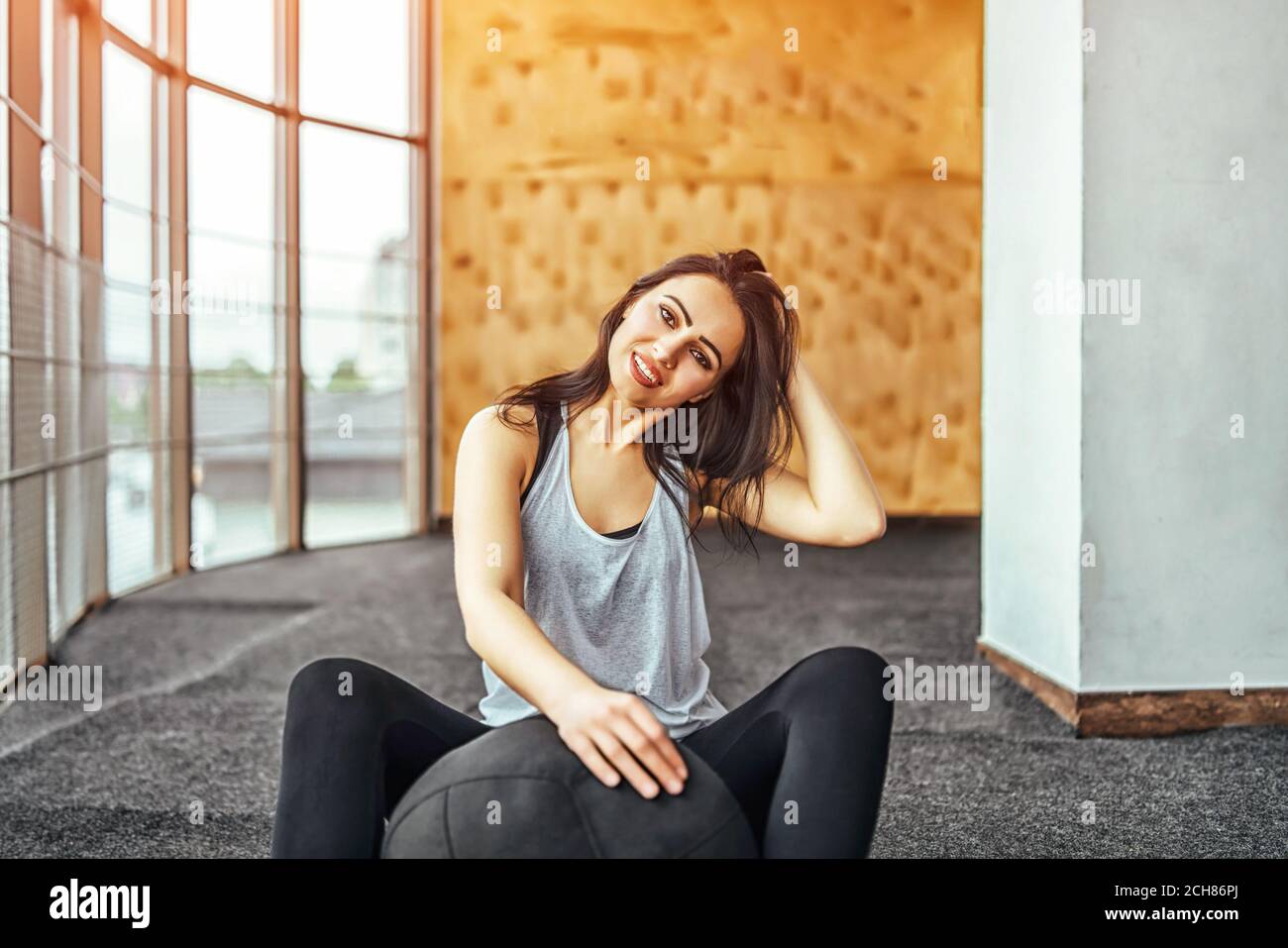 Pretty sporty girl sitting in the gym Stock Photo - Alamy