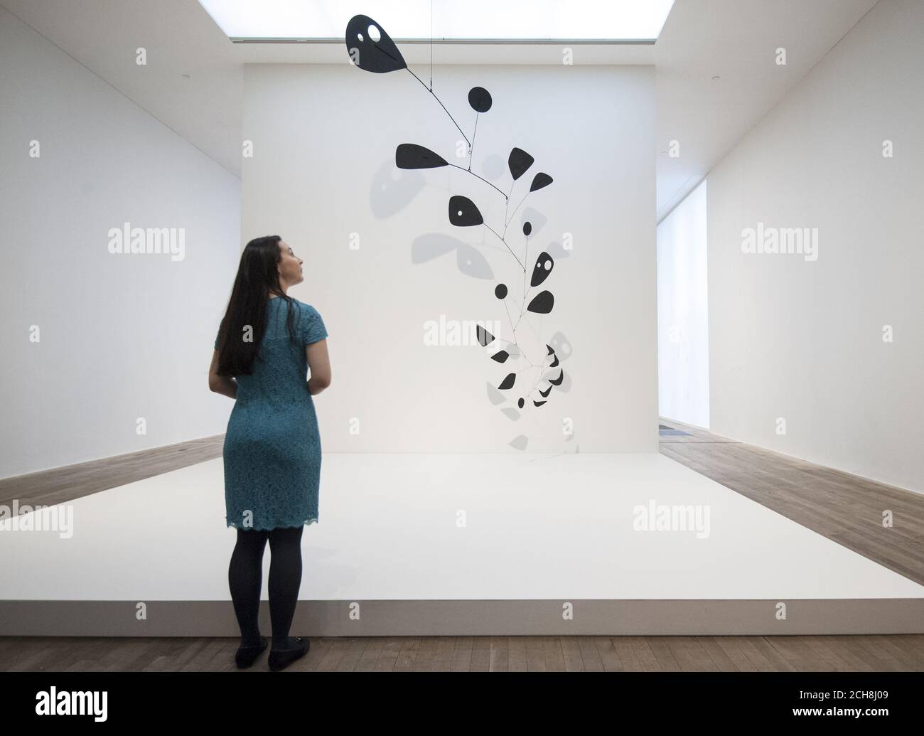 A visitor views Black Widow 1948, part of the Alexander Calder: Performing Sculpture exhibition which is held at the Tate Modern in London between 11 November and 3 April. Stock Photo