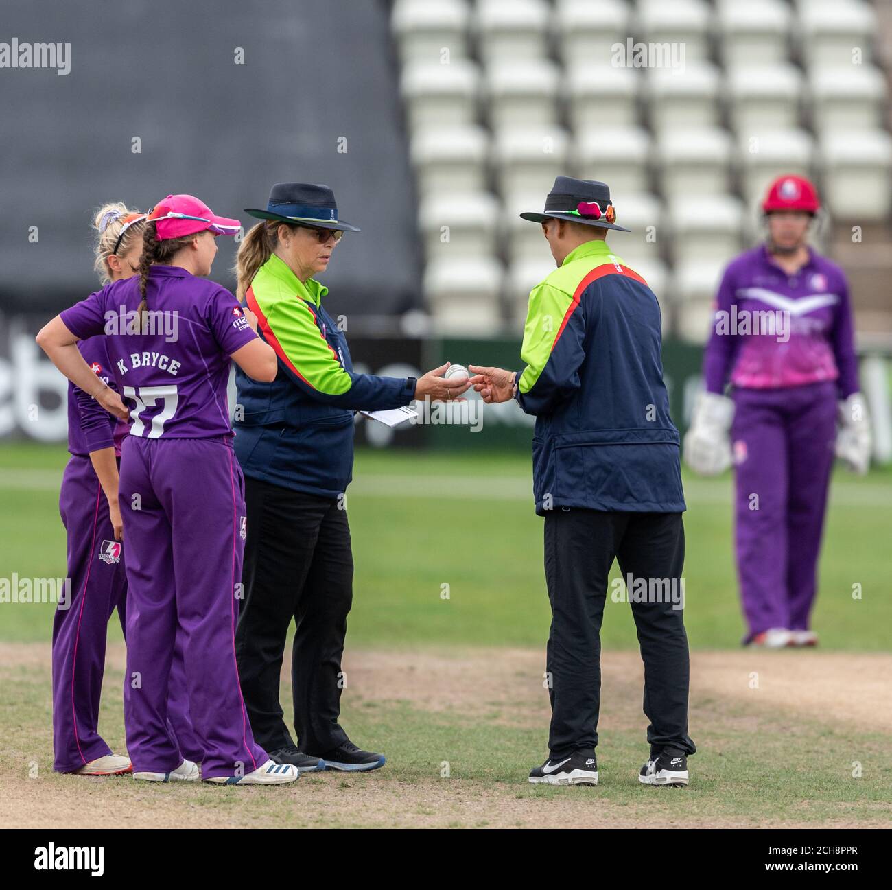 Umpires Hassan Adnan and Yvonne Dolphin-Cooper check the ball in a Rachael Heyhoe Flint Trophy match between Central Sparks and Lightning Cricket Stock Photo