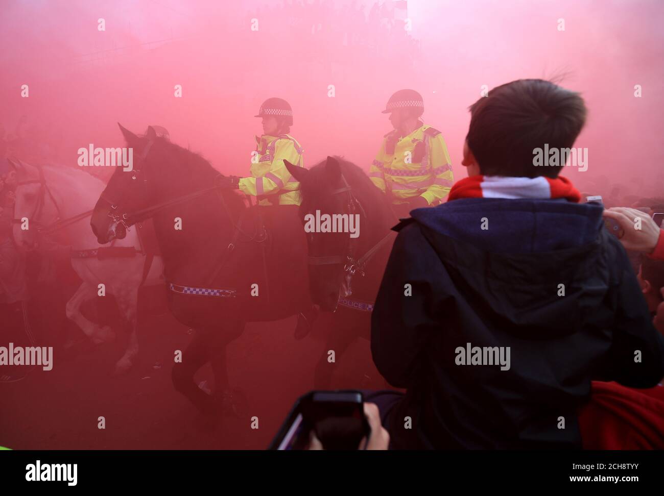 Mounted Police surrounded by Liverpool fans and in red smoke Stock Photo