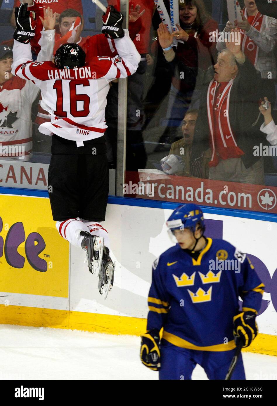 Canada S Curtis Hamilton L Jumps Into The Glass After Scoring As Sweden S Adam Larsson Skates Away During The First Period Of Their Iihf World Junior Championships Game In Buffalo New York December