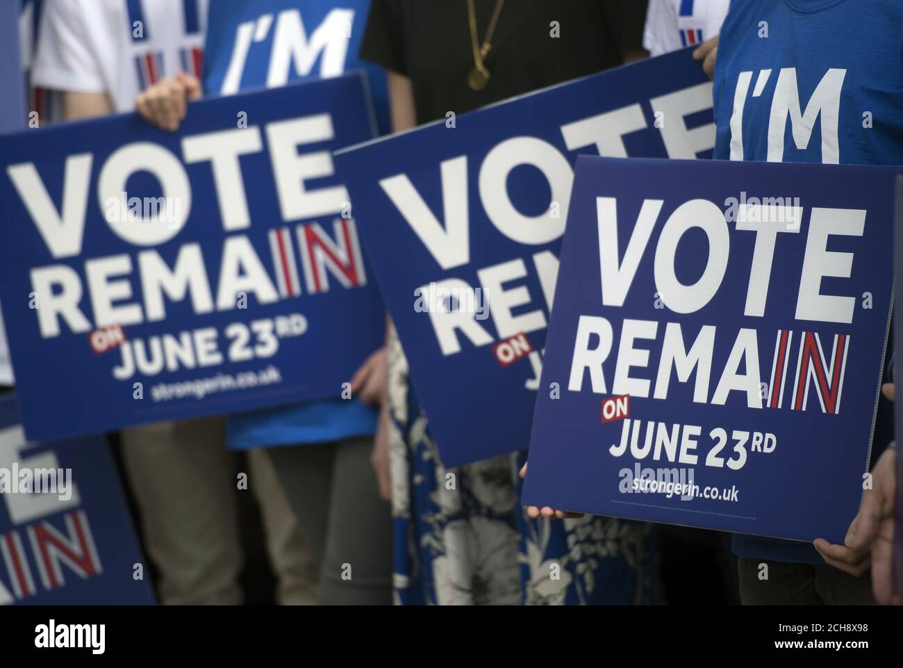 Campaigners hold placards as Prime Minister David Cameron delivers a speech at a Remain campaign event in his Witney constituency in Oxfordshire, where he warned that a vote to leave the European Union could tip the British economy back into recession. Stock Photo