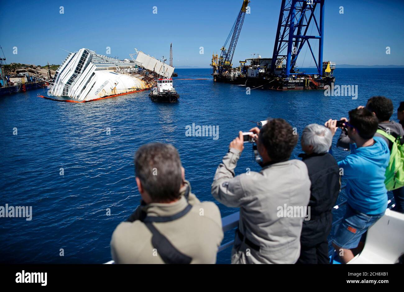 People Take Pictures Of The Capsized Cruise Liner Costa Concordia Lying Surrounded By Cranes Outside Giglio Harbour May 14 2013 Prosecutors Rejected A Plea Bargain Offer By The Captain Of The Cruise