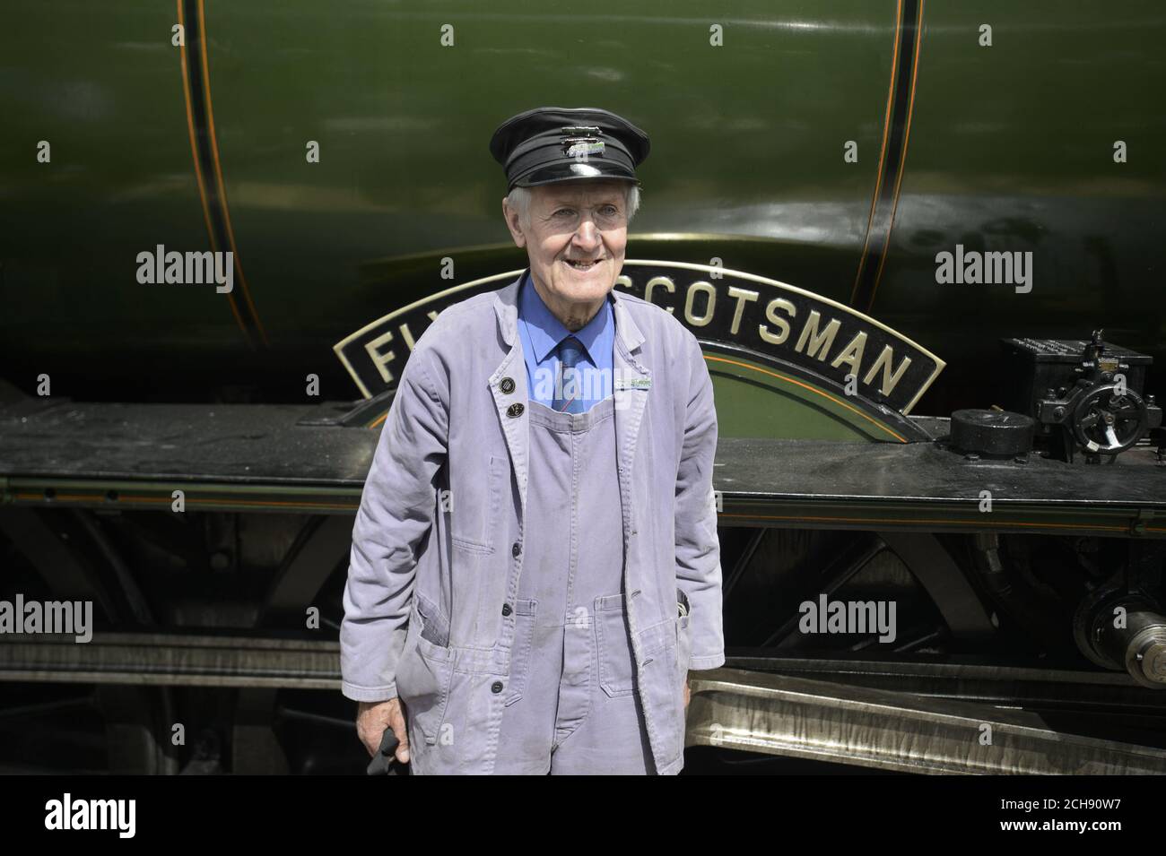 Engine fireman Gordon Hodgson, 77, from Carlisle, is photographed by fans of the train, as Flying Scotsman arrives at Tweedbank railway station from Edinburgh's Waverley station to Tweedbank in the Borders, as it continues its tour of Britain after Network Rail reversed a decision to cancel trips at short notice. Stock Photo