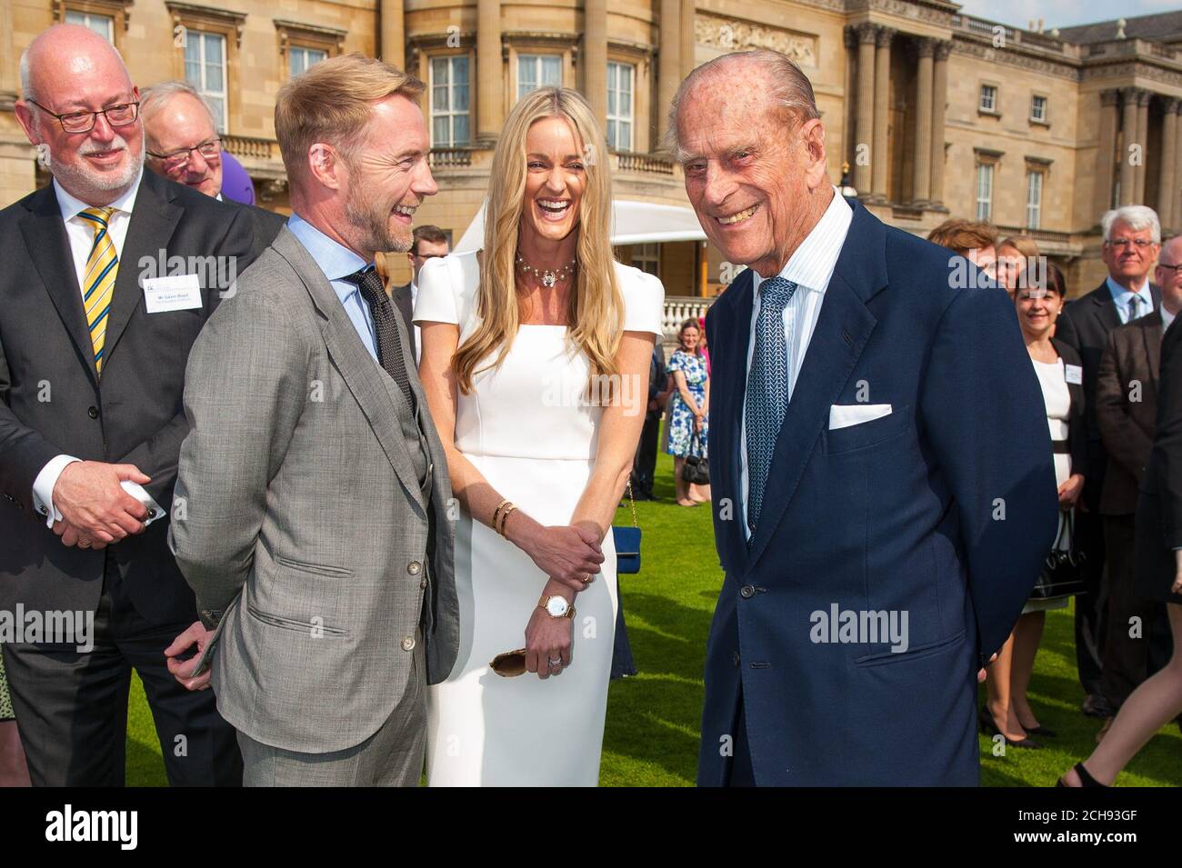The Duke of Edinburgh (right) speaks with Ronan Keating and his wife Storm at the Duke of Edinburgh Award garden party, at Buckingham Palace, London. Stock Photo