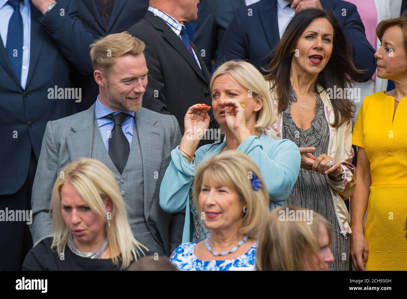 Ronan Keating and Alice Beer talk as celebrity award presenters pose for a group photograph at the Duke of Edinburgh Award garden party, at Buckingham Palace, London. Stock Photo