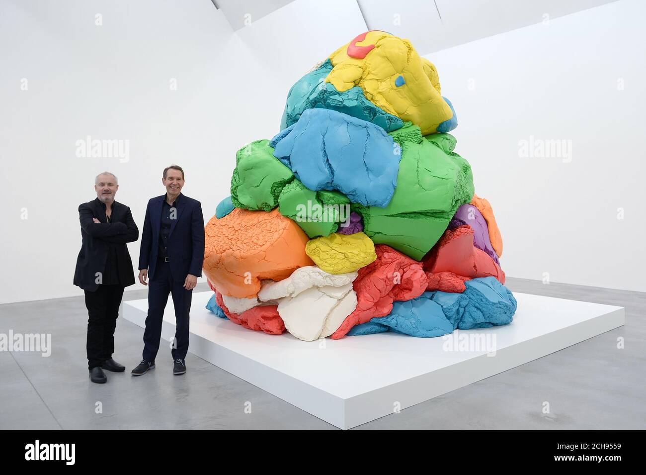 Jeff Koons (right) speaks with Damien Hirst (left) beside his sculpture
