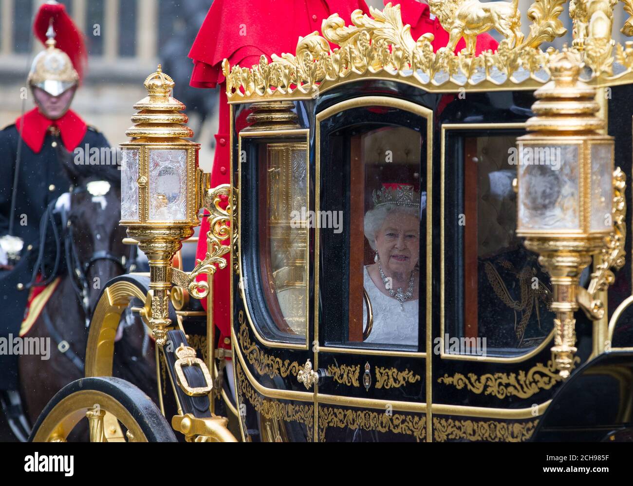 Queen Elizabeth II and the Duke of Edinburgh, travel towards the Houses of Parliament in the Diamond Jubilee state coach for the State Opening of Parliament, in the House of Lords at the Palace of Westminster in London. Stock Photo