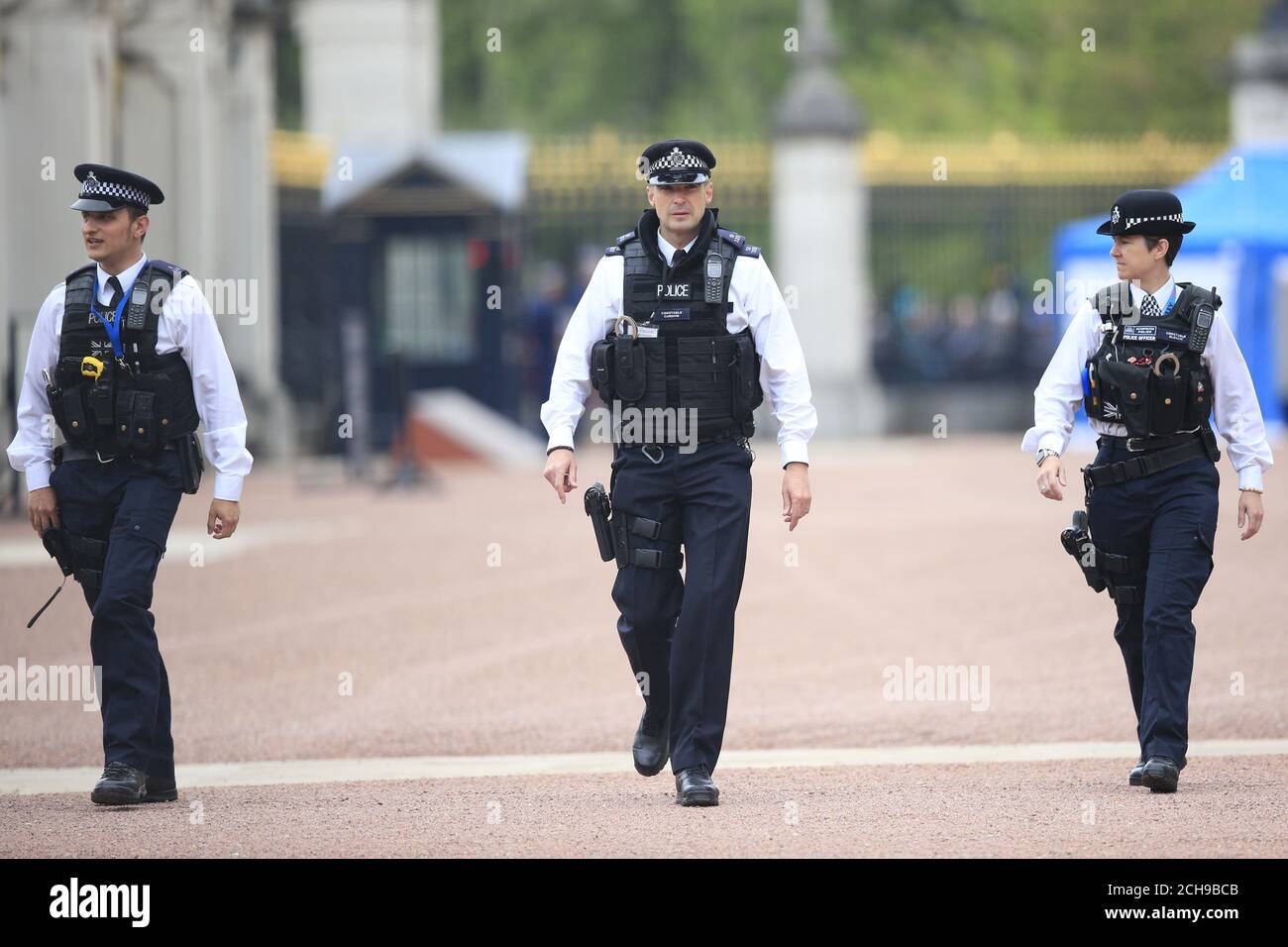 Armed police officers walk in front of Buckingham Palace in central London. Scotland Yard has said that a 41-year-old man was arrested after scaling a perimeter wall at the palace Wednesday night. Stock Photo