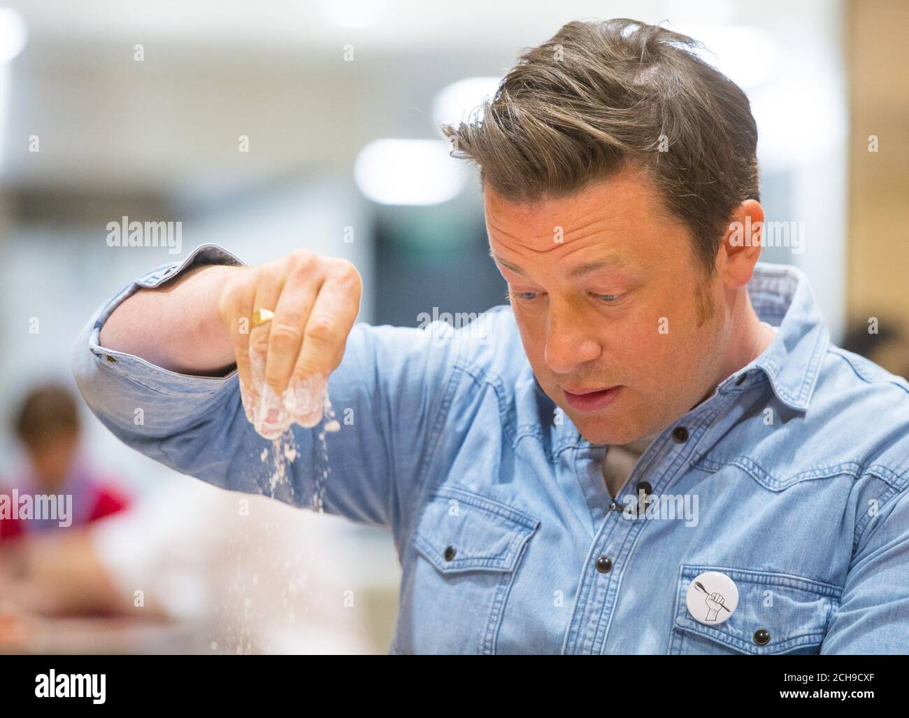 Jamie Oliver makes bread with pupils at Kings Cross Academy in London, during a visit on Food Revolution Day, part of the Food Revolution campaign which aims to tackle issues of child nutrition. Stock Photo