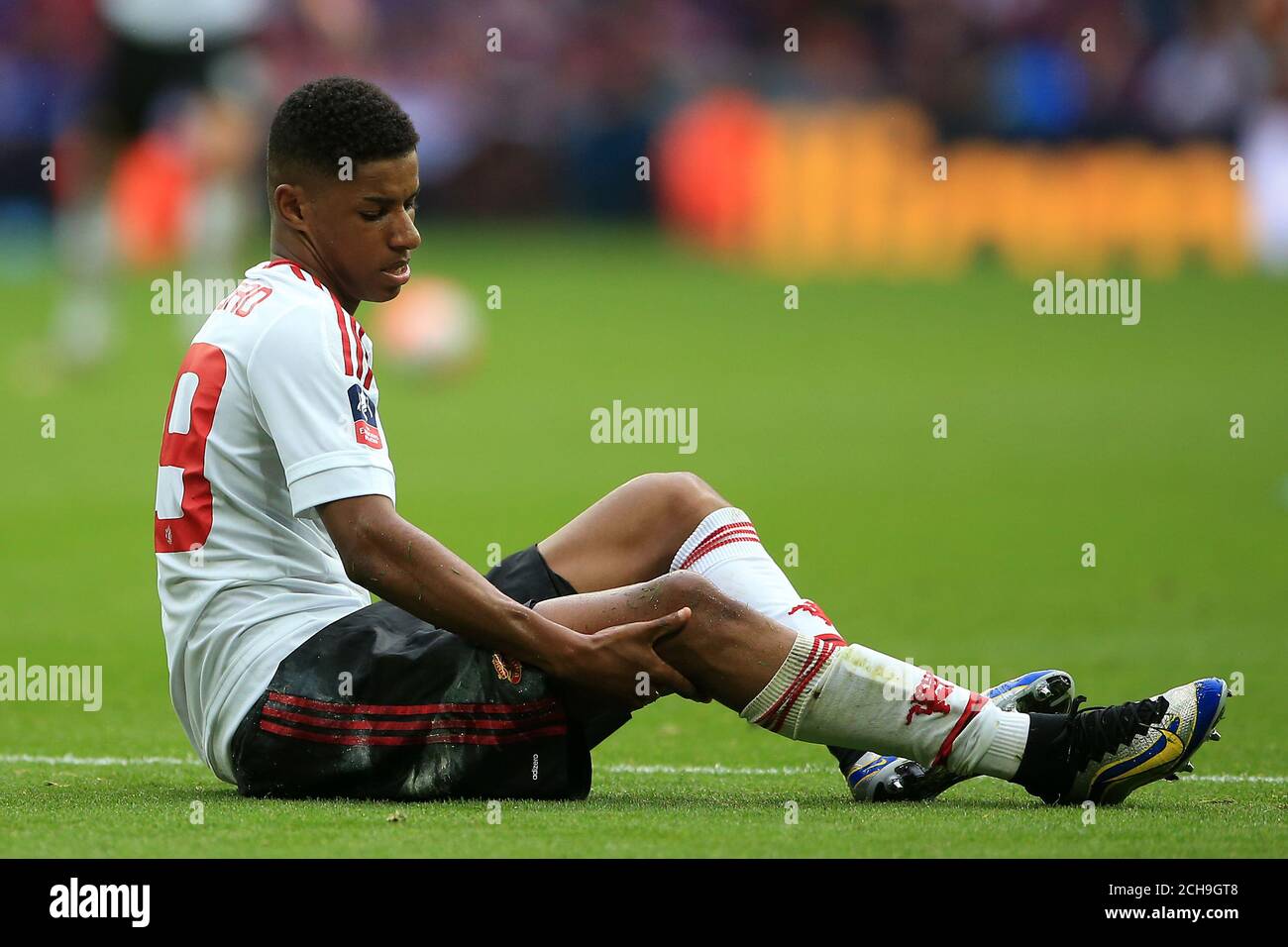 Manchester United s Marcus Rashford holds his knee after taking a