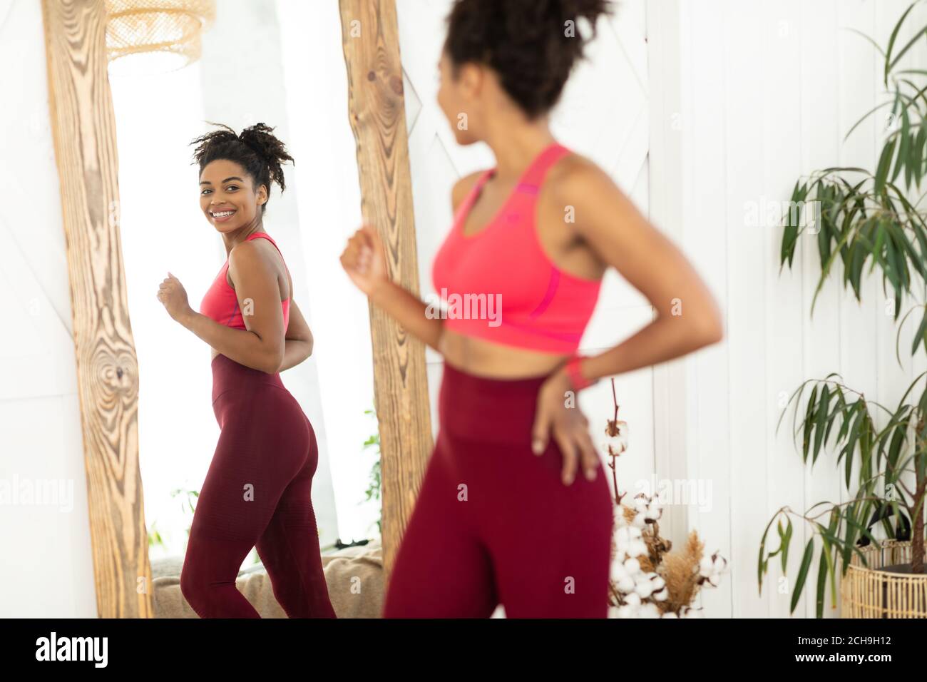 Joyful African Woman After WeightLoss Looking In Mirror Standing