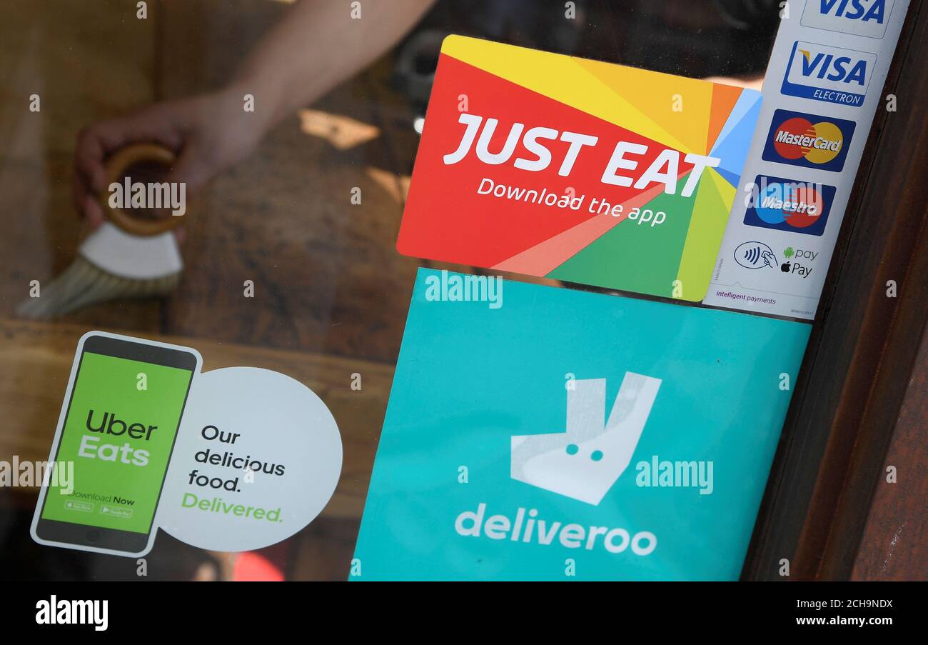 Signage for Just Eat is seen next to Uber Eats and Deliveroo 