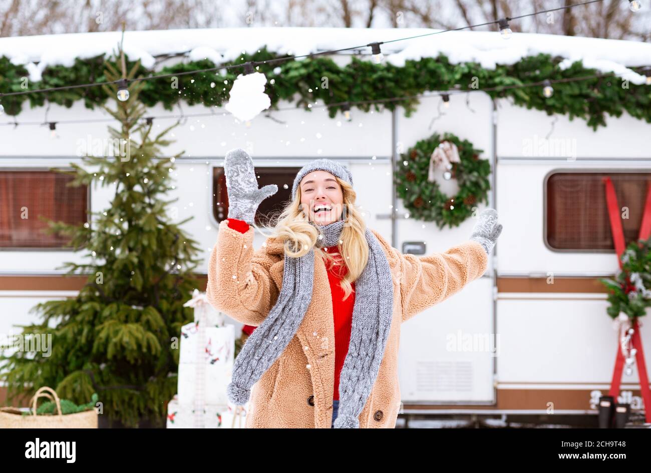 Happy Cheerful Young Woman Throwing Snowball At Camera In Winter Campsite Stock Photo