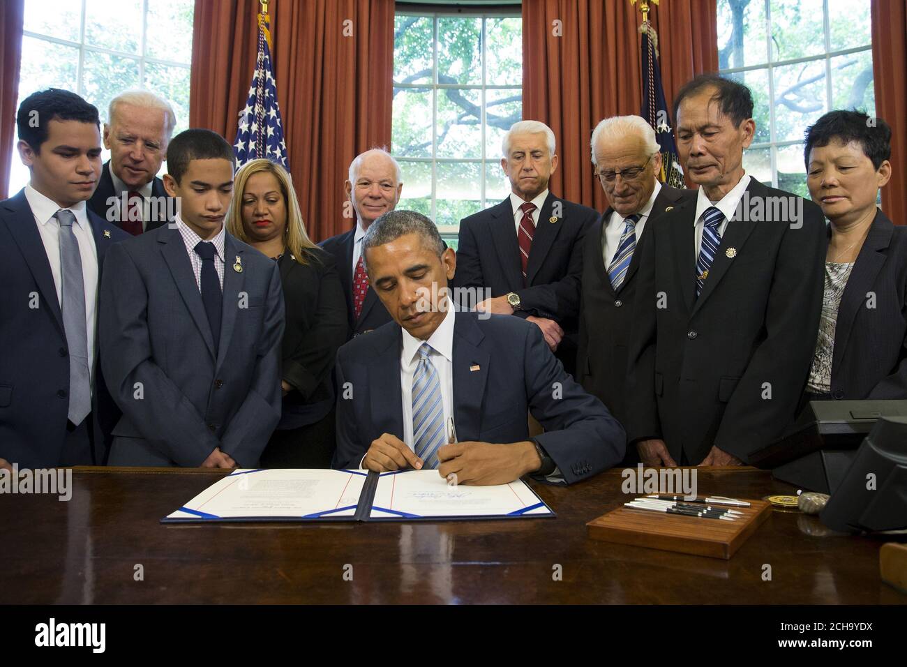 U S President Barack Obama C Is Surrounded By Lawmakers And Family Members Of Slain Police Officers As He Signs The Rafael Ramos And Wenjian Liu National Blue Alert Act Into Law In