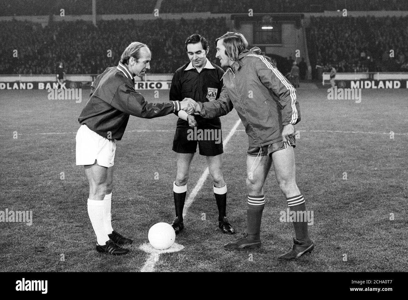Team captains Bobby Charlton (l), Manchester United, captain of the British Three, and Gunter Netzer, of Borussia Moenchengladbach and West Germany, shake hands before the match. Referee is Norman Burtenshaw. Stock Photo
