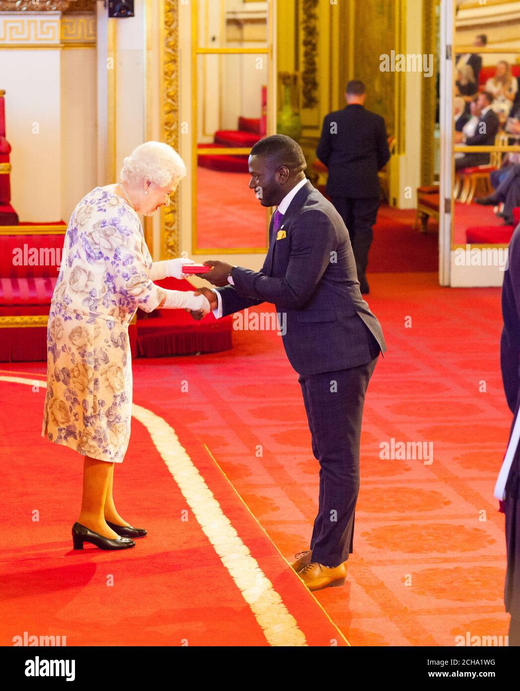 Mr. Tijani Christian from Jamaica receives a medal from Queen Elizabeth II during the Queen's Young Leaders Awards 2016 at Buckingham Palace, London. PRESS ASSOCIATION Photo. Picture date: Thursday June 23, 2016. Photo credit should read: Dominic Lipinski/PA Wire Stock Photo