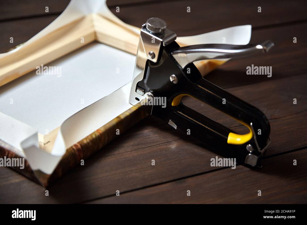 Fastening fabric and board using construction stapler on bright background  Stock Photo by ©belchonock 40884417