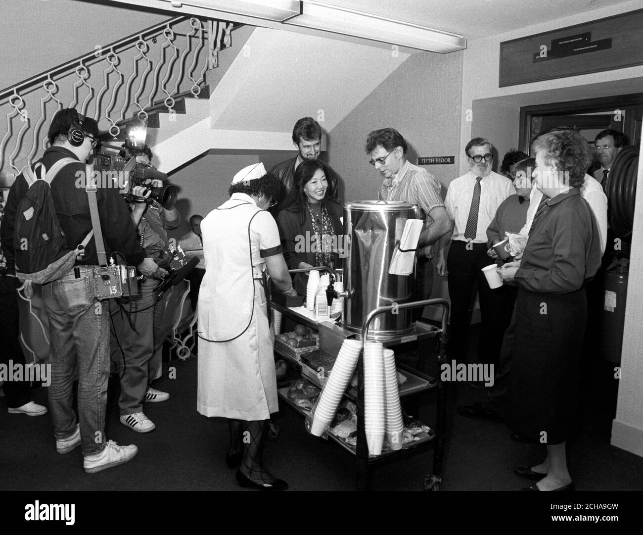 Japanese television crew film the Press Association tea trolley service, one of the last such service in London. Stock Photo