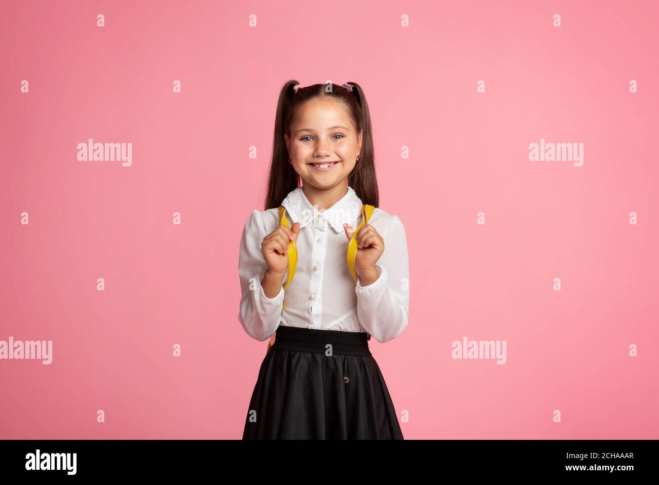 Inspiring education. Little child in school uniform with backpack smiles at camera Stock Photo