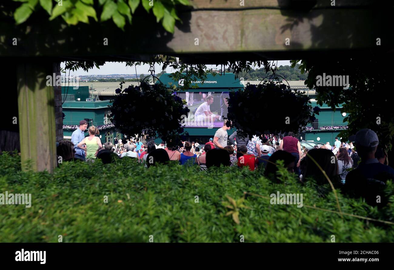Spectators on Murray Mount watch Andy Murray play Jo-Wilfried Tsonga on the big screen on day nine of the Wimbledon Championships at the All England Lawn Tennis and Croquet Club, Wimbledon. Stock Photo