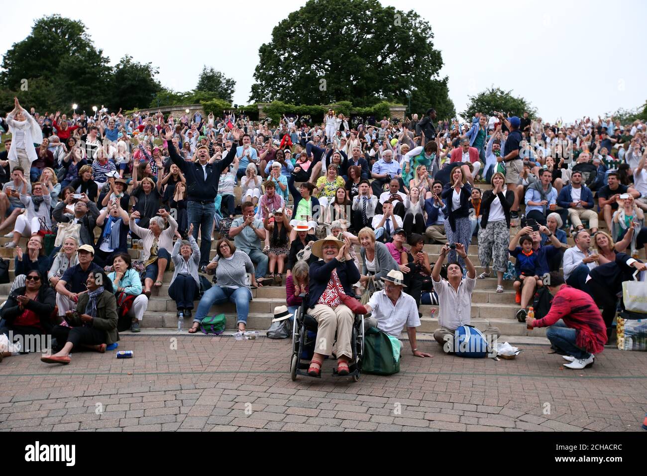 Spectators on Murray Mount celebrate as Andy Murray beats Jo-Wilfried Tsonga on day nine of the Wimbledon Championships at the All England Lawn tennis and Croquet Club, Wimbledon. Stock Photo