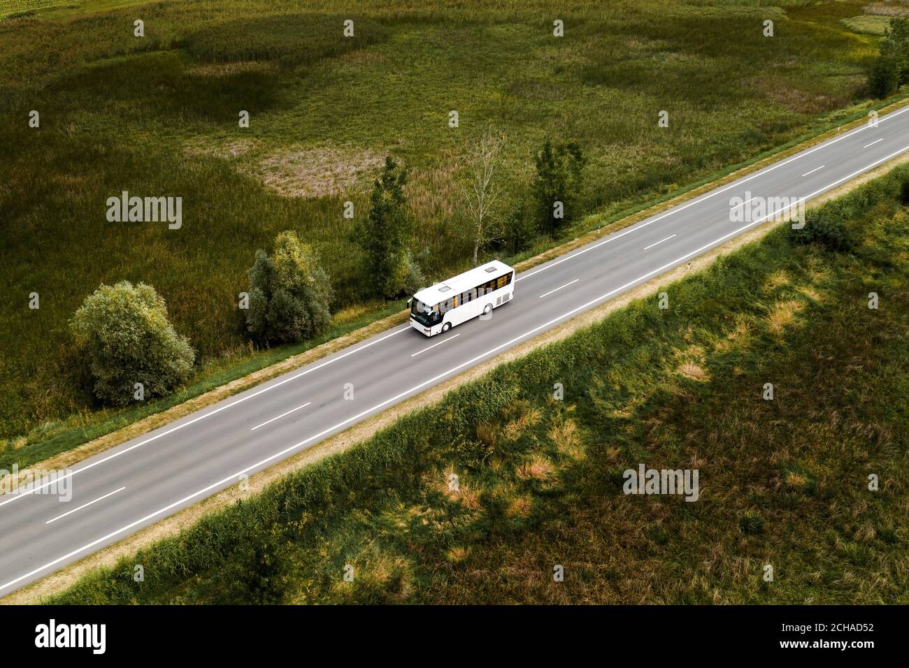 Aerial view of passenger bus on road through countryside from drone pov ...