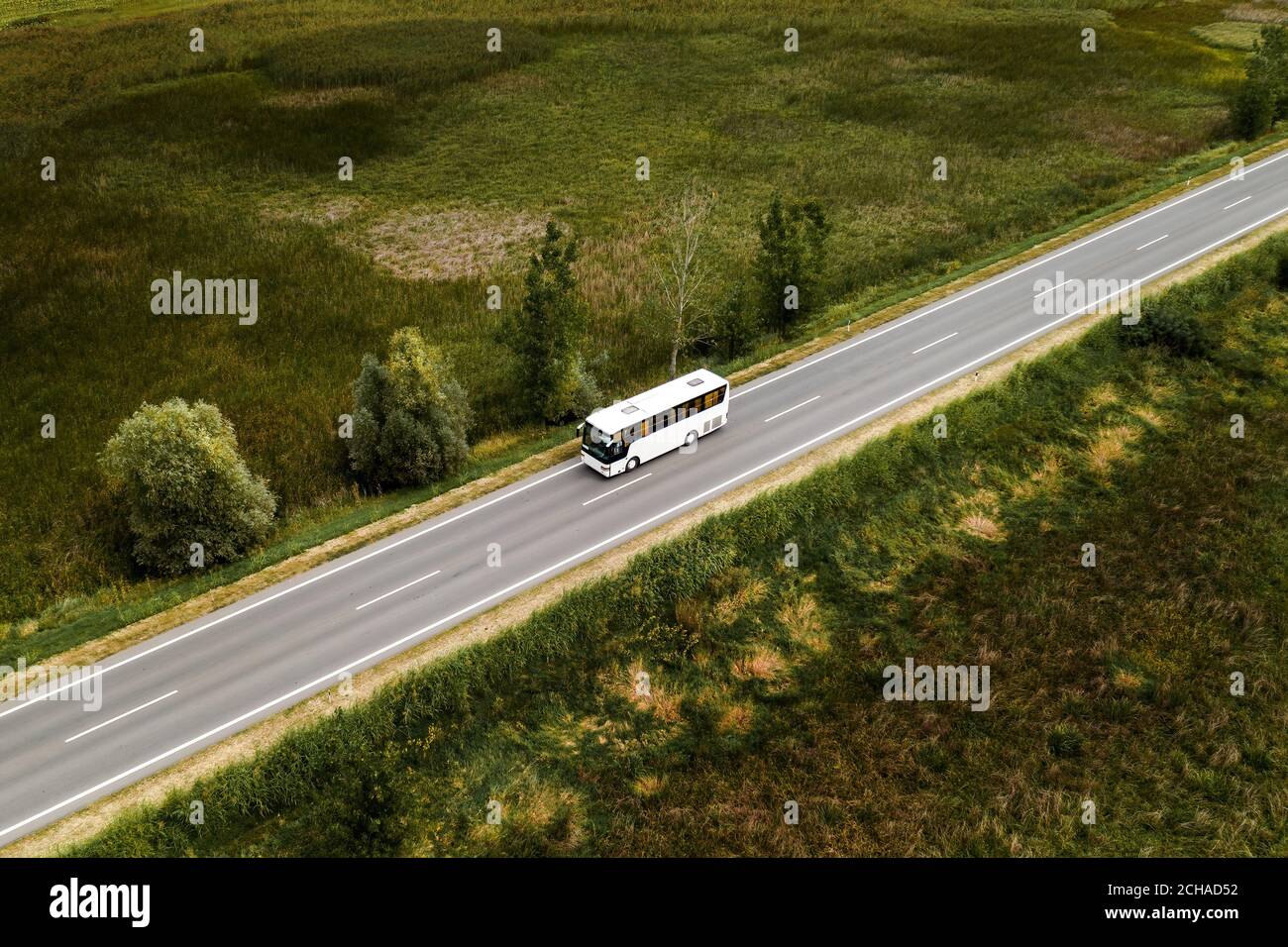 Aerial view of passenger bus on road through countryside from drone pov Stock Photo