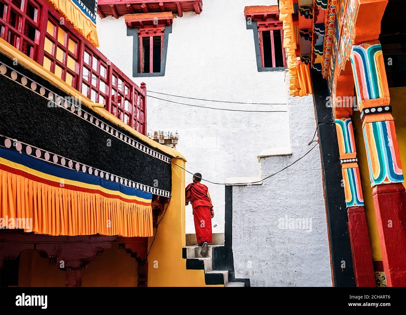 Thiksay Monastery in Thiksey village, India – August 20, 2016: Young monk boy goes by the monastery worn in traditional red kasaya Stock Photo