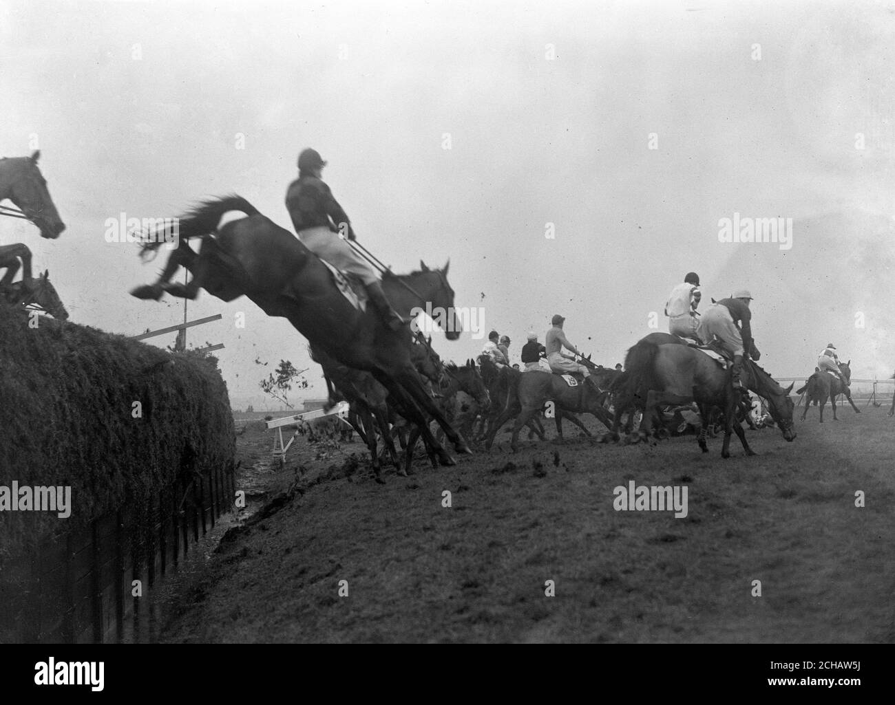 A horse and jockey crash as the field takes Becher's Brook, which