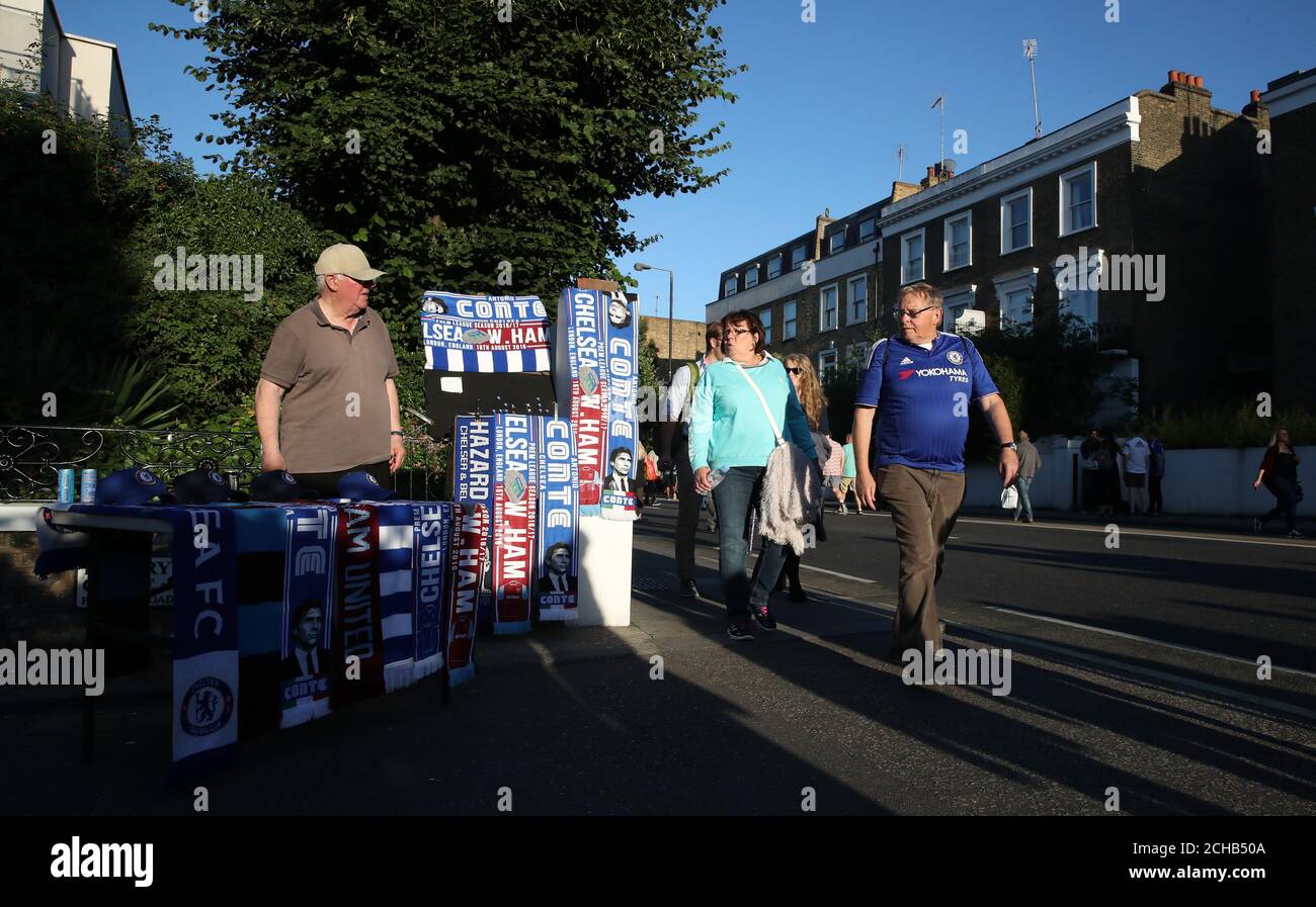 Chelsea fans walk past a stall selling half and half Chelsea and West Ham United scarves Stock Photo